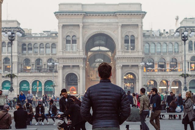Boy seen from behind looking at Piazza Duomo in Milan